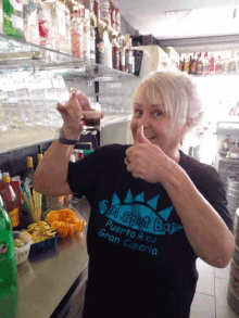 a woman giving a thumbs up wearing a shirt that says sin spot bar