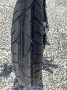 a close up of a tire on a motorcycle on gravel