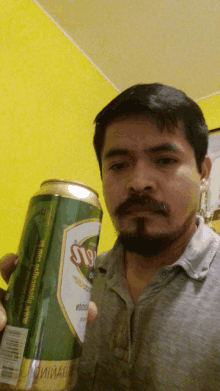 a man with a beard holds a can that says ' ss ' on it