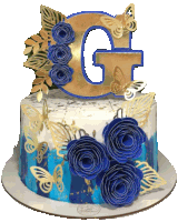 a cake with blue flowers and a gold letter g on top