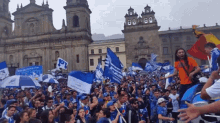 a crowd of people are gathered in front of a building with a sign that says " aguila " on it