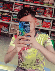 a young man taking a picture of himself with a phone that says ' one ' on the back of it