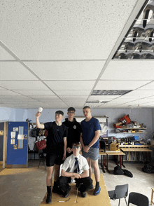 a group of young men are posing for a photo in a room