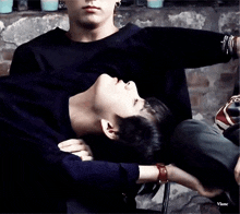 a man is laying on another man 's lap with his head on another man 's lap .