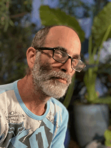 a man with a beard wearing glasses and a shirt that says fox on it