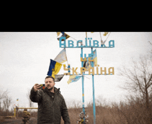 a man taking a selfie in front of a sign that says ' ukraine '