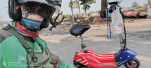 a man wearing a helmet is riding a red white and blue scooter with an american flag on it