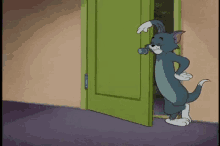 tom from tom and jerry is standing in a doorway .