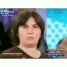 a woman with short brown hair is making a funny face on a television show .