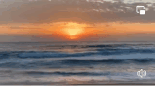 a blurry picture of a sunset over the ocean with a sound icon