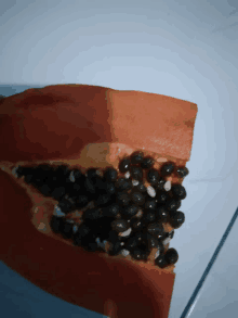 a papaya that has been cut in half with black seeds