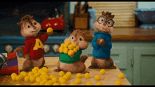 three alvin and the chipmunks are standing on a counter eating candy