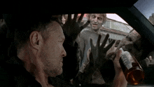 a man in a car with zombies behind him and a sign that says tobacco on it