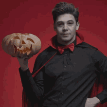 a man in a vampire costume holds a carved pumpkin with the words fangs for being a bloody good friend below him