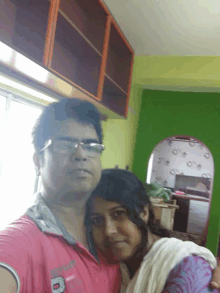 a man and a woman pose for a picture with the man wearing a pink shirt that says ' sydney ' on it