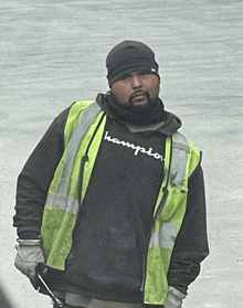 a man wearing a champion shirt and a yellow vest