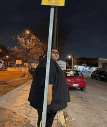 a man standing next to a pole with a sign that says " no dogs "