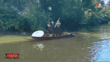 two people in a canoe on a river with a tv screen behind them that says ' ntv ' on it