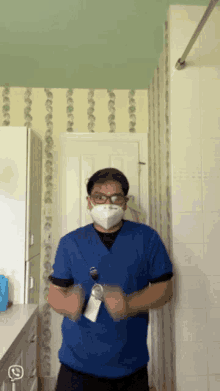 a man wearing a blue scrub top and a face mask