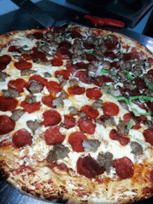 a pizza with pepperoni and sausage sits on a counter