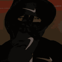 a person wearing a black nike hoodie and black gloves