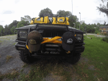 a jeep with two hats and a yellow bag on top of it