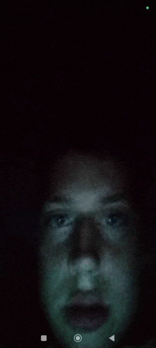 a close up of a person 's face in a dark room .