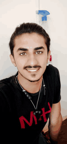 a young man wearing a black shirt that says mh