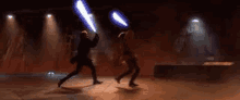 two men are holding lightsabers in a dark room .