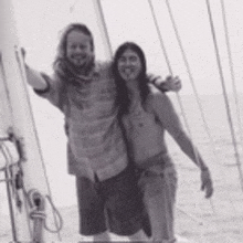 two men are posing for a picture on a boat in the ocean .