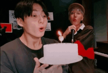 two young men are celebrating a birthday with a cake and candles