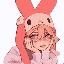 a girl wearing a pink bunny hat with a flower on it is holding her hands to her face .