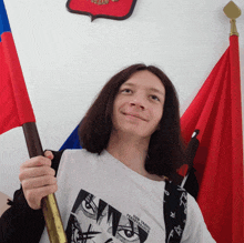 a young man holding a flag with a shirt that says " let 's make freedom free " on it