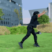 a man in a black shirt and black pants is standing in a grassy field in front of a building that says google