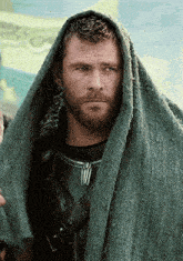 a close up of a man with a beard wrapped in a blanket .