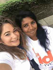 two women are posing for a picture and one is wearing a nyc t-shirt