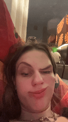 a woman making a funny face while laying on a couch