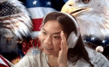 a woman wearing headphones is sitting in front of an american flag