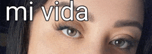 a close up of a woman 's eye with the words " mi vida " below it