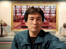 a man in a blue jacket is taking a selfie in front of a painting of a living room