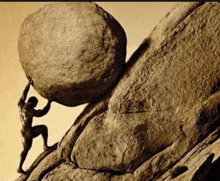 a statue of a man pushing a large rock up a hill