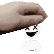 a hand is holding a dead smiley face with x 's crossed out .