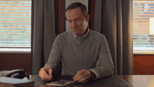 a man sits at a desk looking at a picture