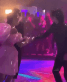 a man and a woman are dancing in a club .