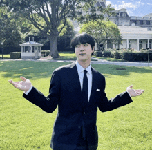 a man in a suit stands in front of the white house