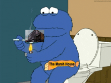 a cookie monster is sitting on a toilet smoking a cigarette and holding a lighter with a picture of a building on it