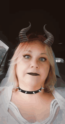 a woman wearing horns and a choker with spikes