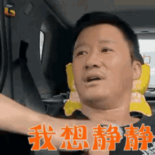 a man is sitting in a car with chinese characters on his face .