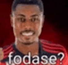 a blurry picture of a man wearing a red shirt with the words fodase ? written on it .