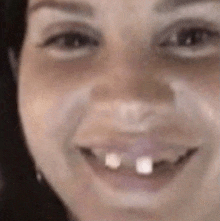 a close up of a woman 's face with a missing tooth .